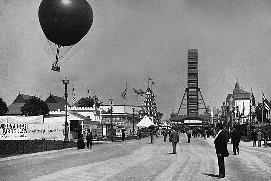 Image of looking down the Midway with ferris wheel in background.
