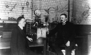 Ernest Rutherford in the lab: Ernest Rutherford sitting in his lab (right) with his assistant, Hans Geiger.