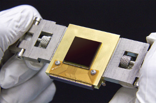 NEOCam Sensor: The Near-Earth Object Camera (NEOCam) is a mission proposed to NASA to find potentially hazardous asteroids. The mission will use a new sensor, called the NEOCam chip, that has more pixels and better sensitivity than previous generations of infrared sensors. Made of mercury, cadmium and tellurium, the new chip is about the size of a postage stamp and is optimized for detecting the faint heat emitted by asteroids circling the Sun. The NEOCam chip is the first megapixel sensor capable of detecting infrared wavelengths at temperatures achievable in deep space without refrigerators or cryogens. Judy Pipher is a member of the science team for NEOCam.