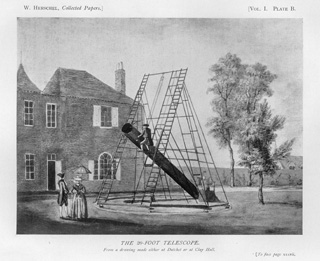 Herschel's Twenty-foot Telescope:  Drawing of the 20-foot telescope from The Scientific Papers of Sir William Herschel published in London in 1912 by the Royal Society and the Royal Astronomy Society.  The drawing depicts an astronomer on a ladder looking through the eyepiece located at the top of the telescope, far from the primary mirror at the foot of the telescope, and an assistant at the foot of the telescope taking notes.