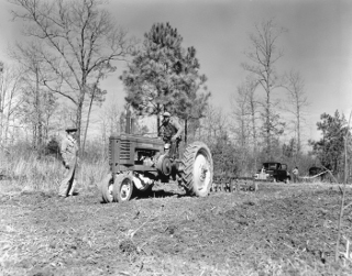 Preparing plant bed, tobacco series, Dinwiddie County: Modern farming requires machinery such as the tractor (foreground) and truck (background) seen in this image.  Learning to use and maintain the equipment often spurs interest and expertise in how machines work.