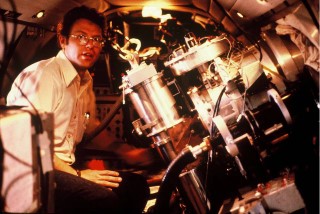 Infrared Spectroscope: Ray W. Russell, a member of the Cornell research group, around 1980, with an infrared spectroscope mounted on the 12-inch telescope in NASA’s Lear Jet Observatory. The Cornell group used this instrument to discover the 158-micron far-infrared radiation emitted by singly-ionized carbon.  Ionized carbon consists of carbon atoms with one electron removed. This form of carbon is a powerful cooling agent in interstellar space.