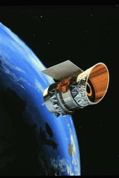 IRAS in Orbit: The artist's rendering shows the Infrared Astronomical Satellite (IRAS) in its 560-mile-high, near-polar orbit above the Earth. From this vantage point, IRAS searched the sky for stars and other infrared-emitting sources, unhampered by the obscuring effects of Earth's atmosphere.