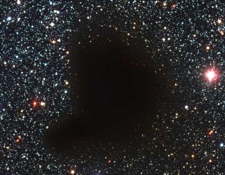 Hole in the Sky: Where did all the stars go? What used to be considered a hole in the sky is now known to astronomers as a dark molecular cloud. Here, a high concentration of dust and molecular gas absorb practically all the visible light emitted from background stars. The eerily dark surroundings help make the interiors of molecular clouds some of the coldest and most isolated places in the Universe. One of the most notable of these dark absorption nebulae is a cloud toward the constellation Ophiuchus known as Barnard 68, pictured above. That no stars are visible in the center indicates that Barnard 68 is relatively nearby, with measurements placing it about 500 light-years away and half a light-year across. It is not known exactly how molecular clouds like Barnard 68 form, but it is known that these clouds are themselves likely places for new stars to form. It is possible to look right through the cloud in infrared light.